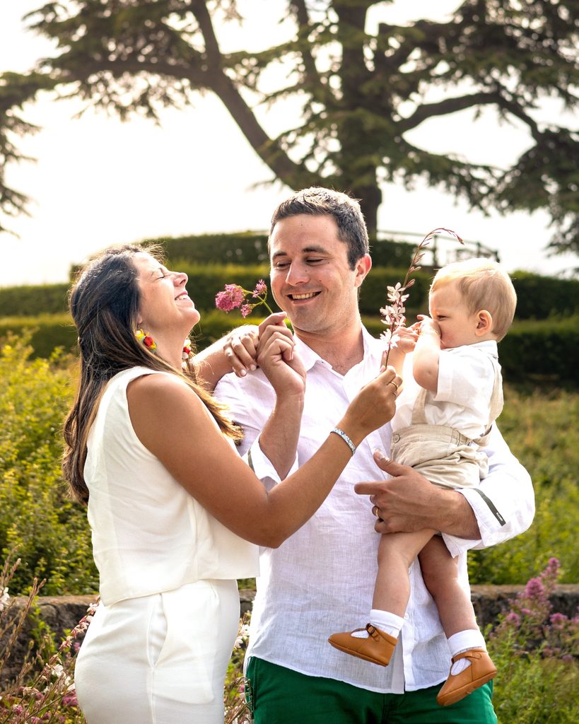 Famille souriante avec enfant dans le jardin fleuri de l'abbaye aux dames, photographe famille Caen